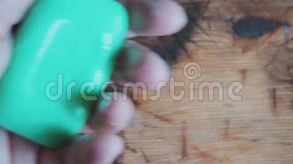 一个男人把一块绿肥皂放在湿手掌里拉手浴室准备清洗背景木材纹理视频的预览图