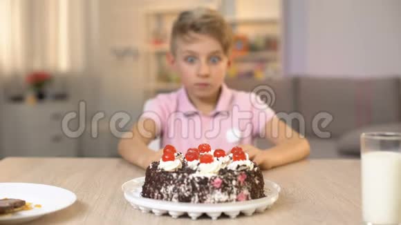 快乐男孩吃樱桃从奶油蛋糕甜点童年小吃视频的预览图