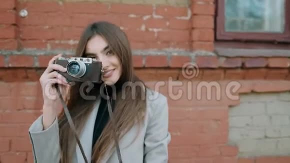拿着老式相机的漂亮女孩带着复古相机的女人正在开心地嬉笑视频的预览图