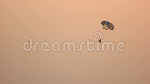 一对夫妇乘着降落伞飞向日落的天空视频的预览图