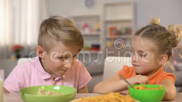 快乐的小男孩和小女孩互相扔玉米片在家里玩得很开心视频的预览图