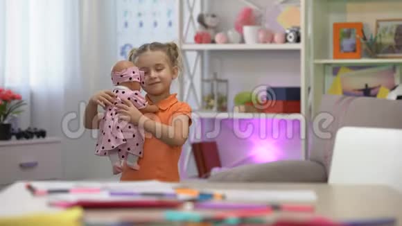 女孩抱着娃娃拥抱最喜欢的玩具女孩休闲童年快乐视频的预览图