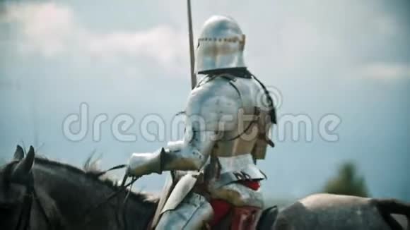一个骑士骑着马在战场上转悠招呼站在栅栏后面的人们致意举起他的手视频的预览图