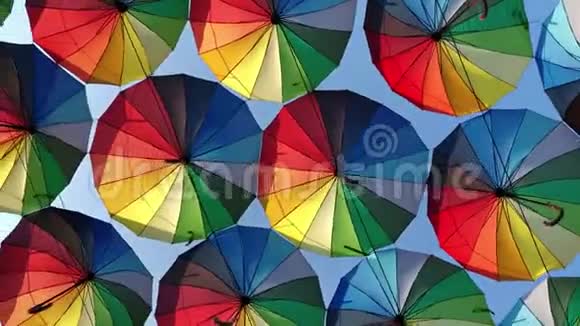 许多五颜六色的彩虹伞挂在公园的小巷里天空阴云密布视频的预览图