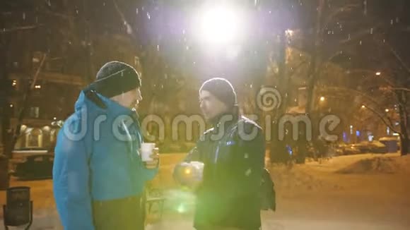 这两个人在冬天在街上聊天喝咖啡圣诞集市视频的预览图