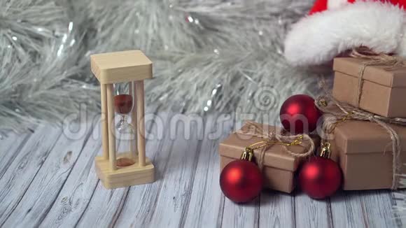 玻璃和纸板箱放在木桌上上面装饰着花环和红色圣诞球或XMAS视频的预览图