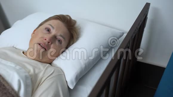 好心的医生抚摸老年女性的肩膀老年病人躺在病床上康复中心视频的预览图
