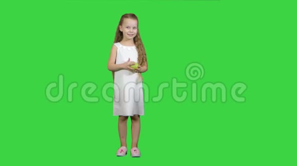 带着绿苹果的小女孩在绿色屏幕上吃Chroma键视频的预览图