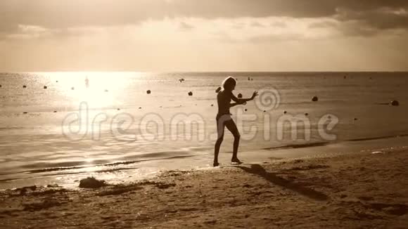 剪影海滩女孩站在手上的生活方式暑假海滩度假的概念视频的预览图