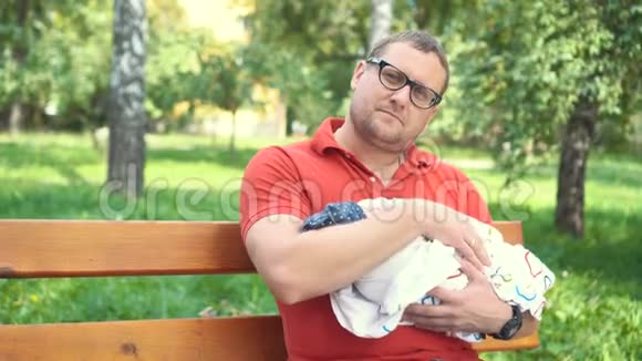 一位运动的年轻父亲把一个赤裸的新生婴儿放在手上父亲节视频的预览图