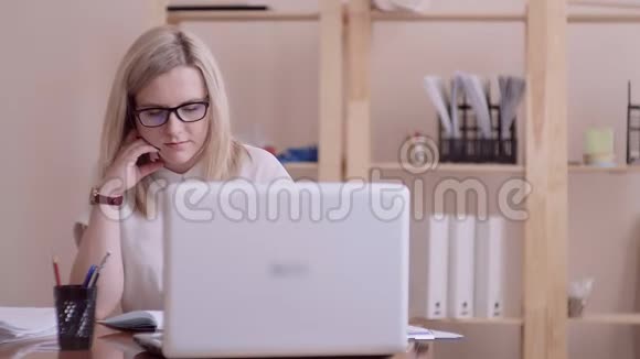 戴着眼镜和白衬衫的金发女孩白种人有兴趣在办公室阅读和研究商业文件视频的预览图