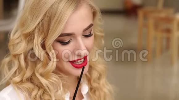 一个性感的金发女郎的肖像她的化妆鲜艳手里拿着刷子艺术视频的预览图