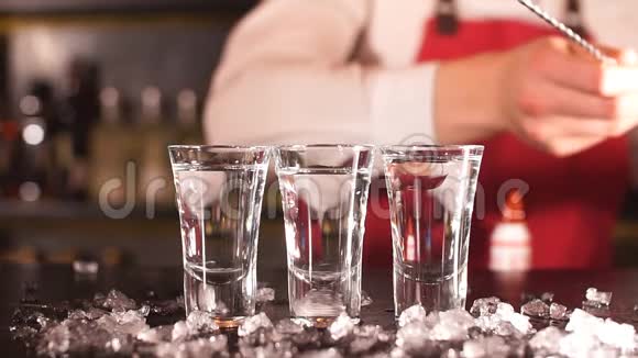 酒保在冰镇伏特加酒杯中加入冰块视频的预览图