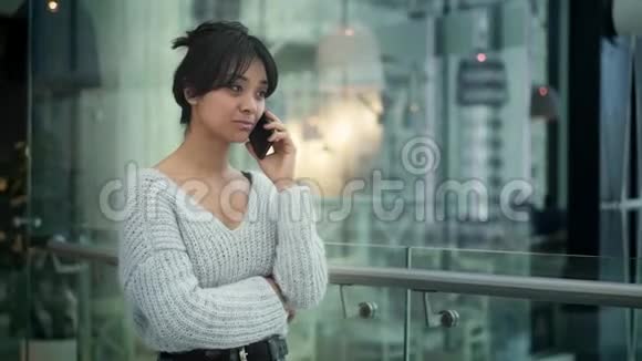 中档慢镜头亚洲女性走路时在电话中笑视频的预览图