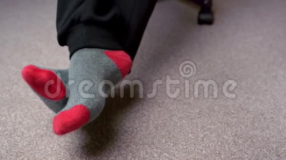 穿着红灰色袜子的脚在浅棕色地毯上椅子上有个男的视频的预览图