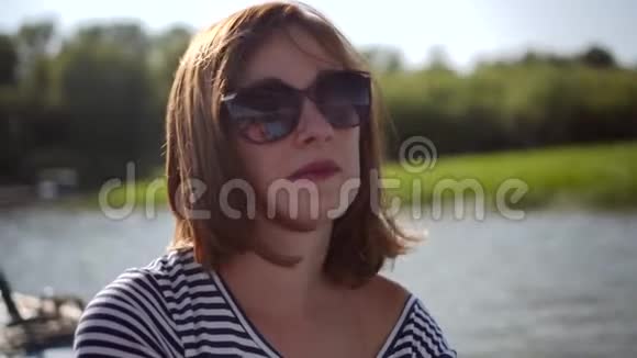 可爱的戴墨镜的红发女人坐船四处旅行视频的预览图