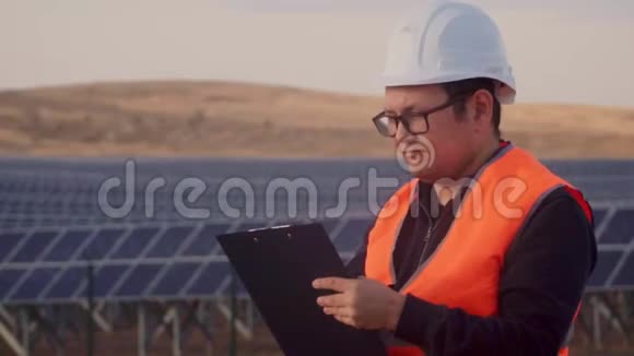 工程师穿着橙色背心和白色头盔看着远处严肃的脸写给平板电脑视频的预览图