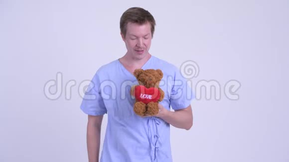 快乐的年轻人抱着泰迪熊表现得很孩子气视频的预览图