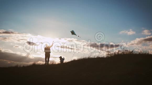 幸福的家庭父亲和孩子女儿在日落时在草地上放风筝有趣的家庭时光友好家庭的概念视频的预览图