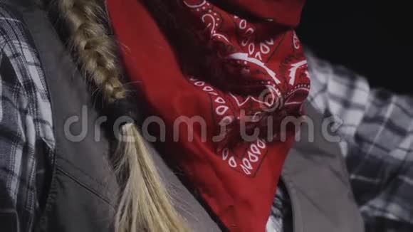 一个戴着帽子的金发女牛仔戴上她的红色手帕4k视频的预览图
