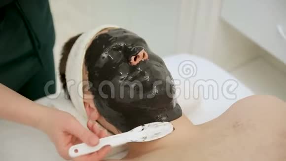 为接受面膜的帅哥提供水疗疗法接待一位美容师视频的预览图