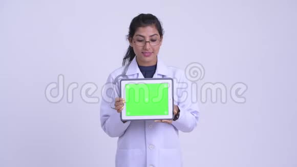 年轻快乐的波斯女医生在看数字平板电脑视频的预览图