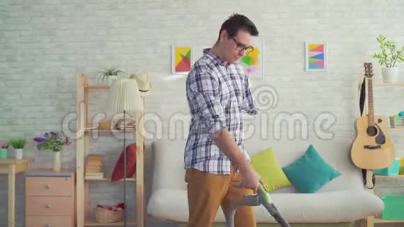 无手残疾的肖像青年正在用吸尘器打扫房子视频的预览图