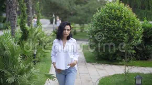 公园里美丽的鞑靼女孩走在人行道上视频的预览图