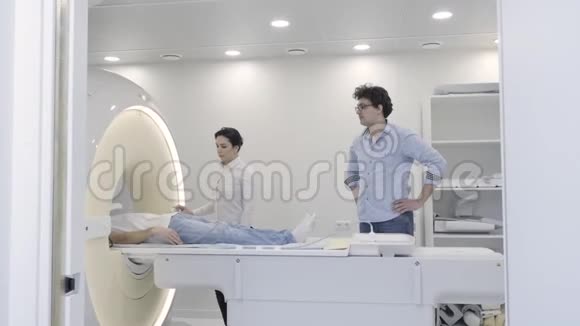 专业女性在诊断过程中控制MRI扫描仪视频的预览图