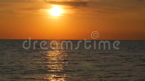 大海上的晚霞或黎明水面上巨大的圆形太阳在海中反射出模糊的阳光视频的预览图