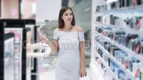 美丽的女孩带着篮子去化妆品商店慢动作稳拍视频的预览图