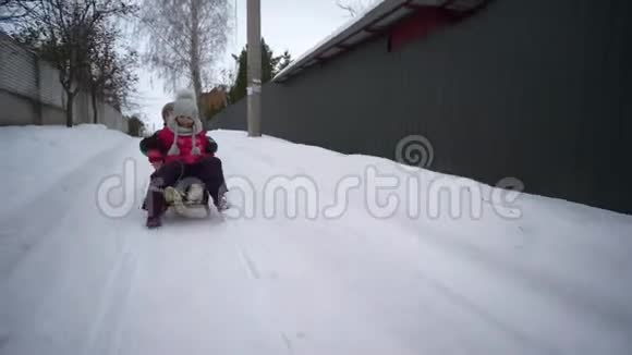 冬天的孩子们娱乐快乐的小男孩和女孩骑在雪道上的雪橇上视频的预览图