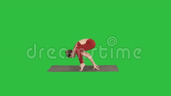 美丽的女人练习倒立瑜伽体式萤火虫姿势在绿色屏幕色度键视频的预览图
