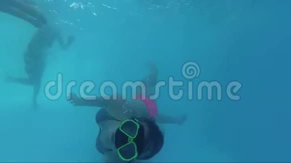 快乐男孩和女孩穿着面具在泳池里潜水视频的预览图