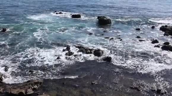 海浪冲刷着岩石海滩视频的预览图