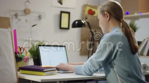 年轻女子在笔记本电脑上工作喝咖啡视频的预览图