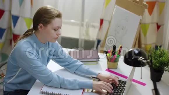 年轻的书生在笔记本电脑上做作业视频的预览图