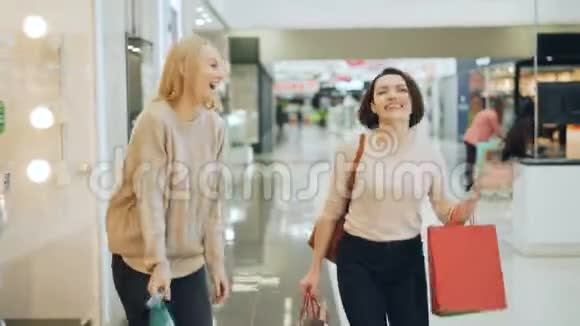 漂亮的女学生正一起在购物中心散步玩得开心聊天笑着拿着纸袋视频的预览图