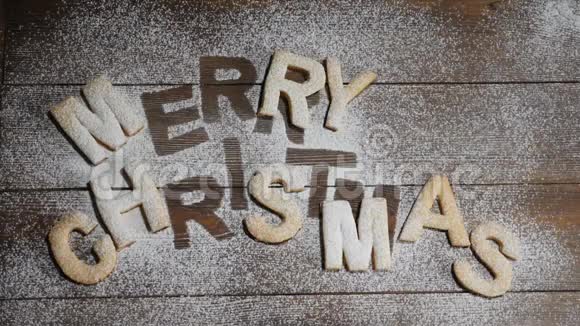 新年快乐圣诞快乐纸条上面写着饼干上面写着白色粉末的棕色木板视频的预览图