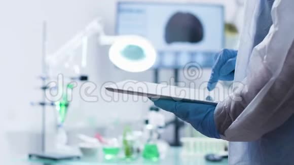化验师戴手套在数码平板电脑上打字视频的预览图