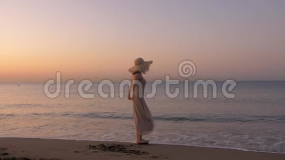 快乐健康浪漫的女人穿着连衣裙和草帽在海滩上兜圈子视频的预览图