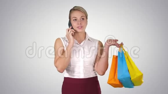购物妇女用智能手机打电话拿着购物袋走路阿尔法频道视频的预览图
