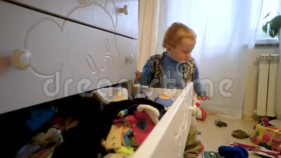 有趣可爱的小男孩从衣柜里得到干净的东西视频的预览图