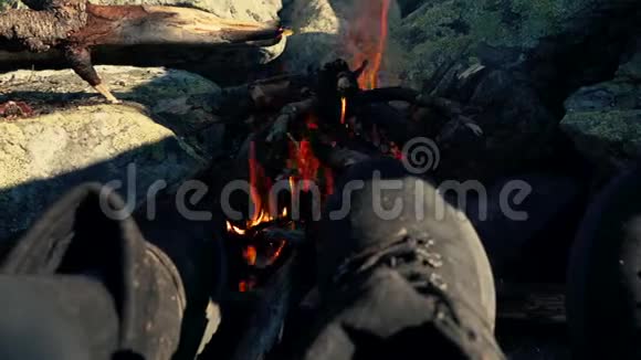 旅行者在山上用营火暖脚视频的预览图