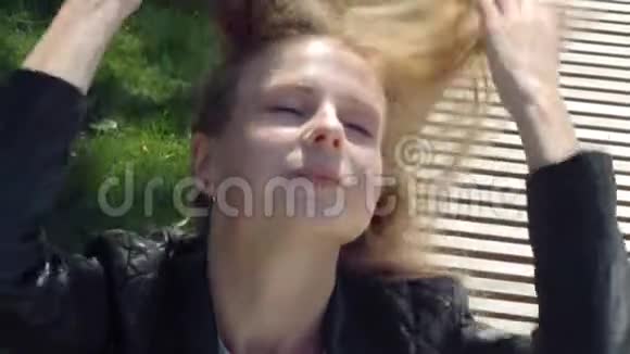 特写公园里穿着街服的年轻漂亮女孩在风中溶解棕色的长发剪头发的照片视频的预览图