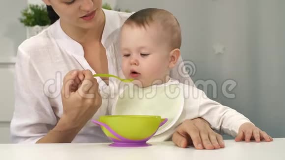 带着碗和勺子的婴儿试着吃视频的预览图