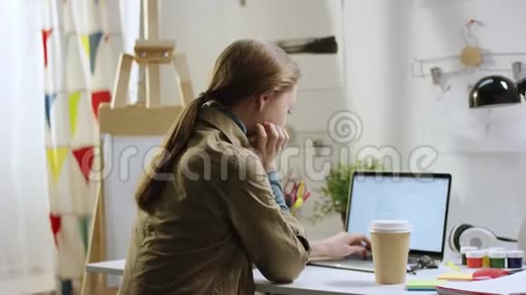 女人用笔记本电脑上网喝咖啡视频的预览图