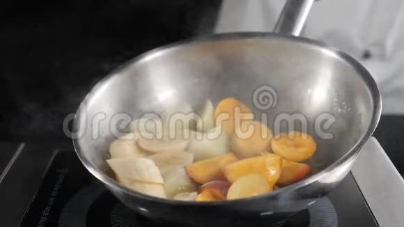 用水果做甜点香蕉杏和桃子厨师搅拌和炒锅与焦糖化视频的预览图