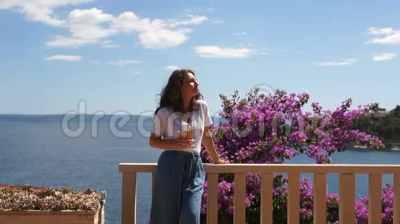 地中海的海景女孩从美丽的木地上眺望海景带着鲜花露台视频的预览图