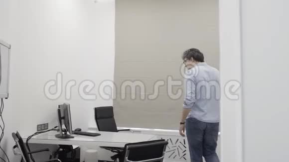 医生早上到诊所办公室打开个人电脑视频的预览图